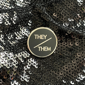 They/them pronoun pin from Queen On The Scene. Sleek and professional round design.