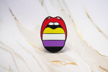Load image into Gallery viewer, A tongue-shaped enamel pin featuring the Progress Pride flag colors (red, yellow, white, purple, black) on a white and gold marble surface.
